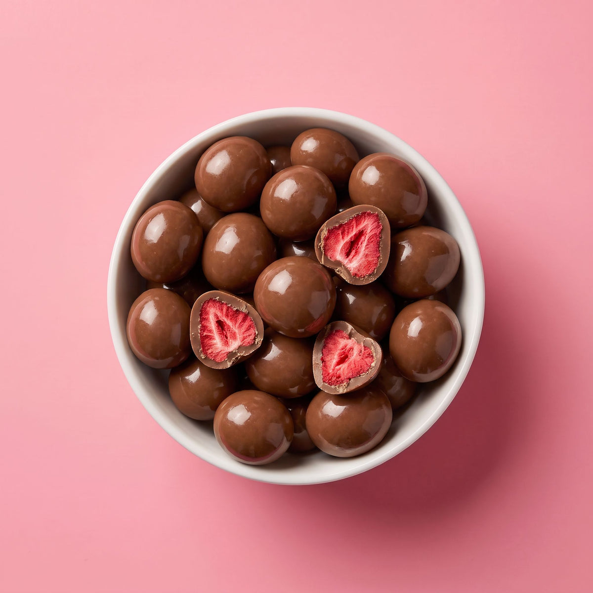 Schaal met Fruelle Classic Milk: gevriesdroogde aardbeien omhuld met melkchocolade, waarvan enkele zijn doorgesneden