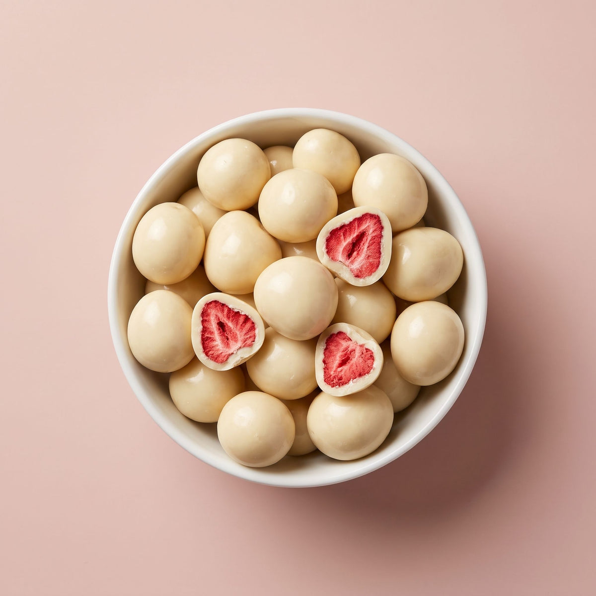 Schaal met Fruelle Pearl White: gevriesdroogde aardbeien omhuld met witte chocolade, waarvan enkele zijn doorgesneden